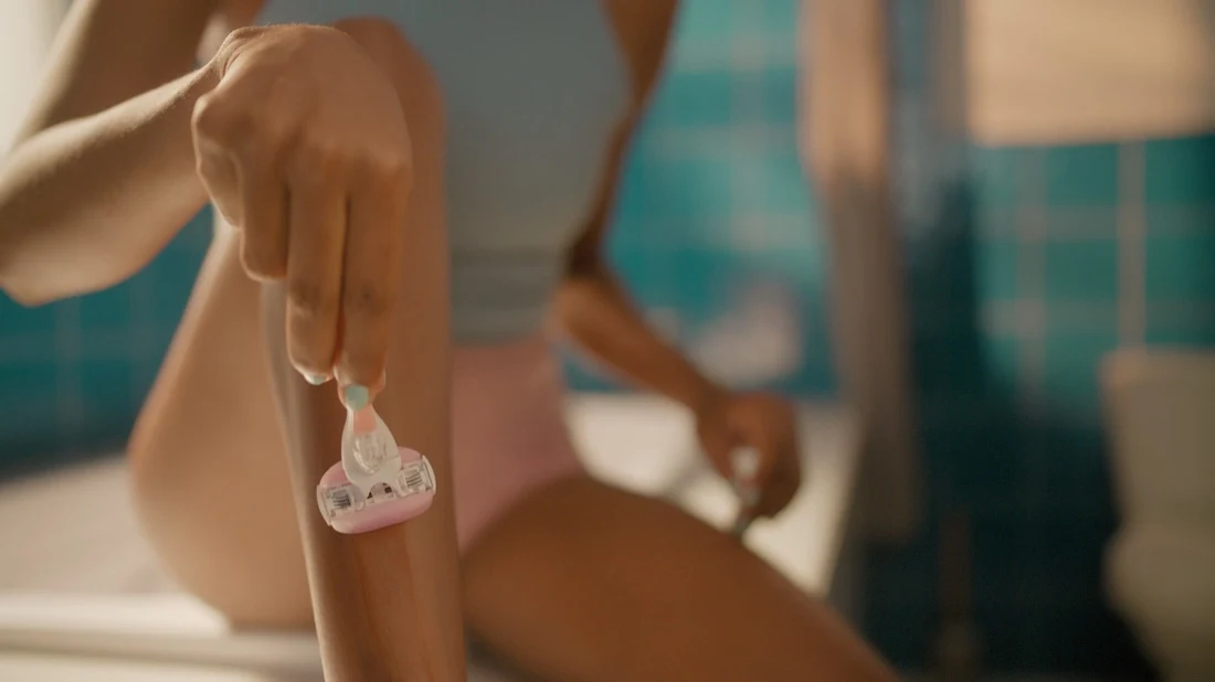 Venus ComfortGlide Freesia razor video showing close-up shot of a woman shaving her leg.