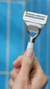 Female hand holding Gillette Venus razor for pubic hair and skin with a square razor head