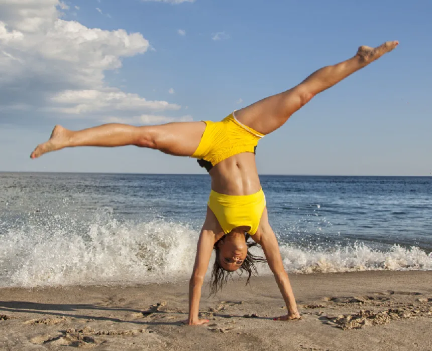 Woman doing cartwheel on the beach