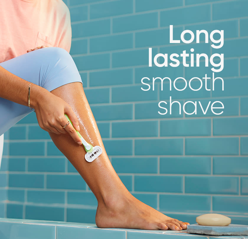 Woman shaving her leg with Gillette Venus Extra Smooth razor, in the bathroom.