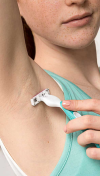 Woman shaving her underarm area with a razor