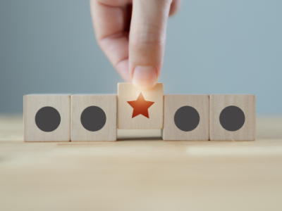 Hand pulling a star out from building blocks for outsourcing