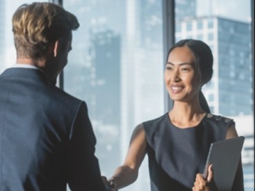 young woman advisor shakes hands with her mentor after agreeing on a development path
