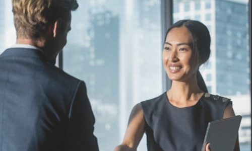 young woman advisor shakes hands with her mentor after agreeing on a development path