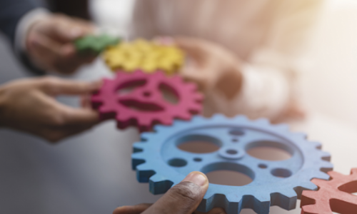 hands holding gears representing trends in M&A
