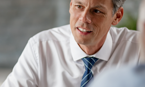 Male financials advisor engaging in a conversation with clients.