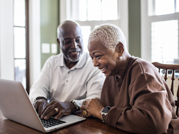 Smiling senior couple on laptop