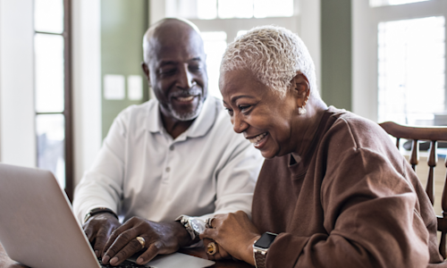 Smiling senior couple on laptop
