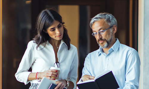 a businesswoman and businessman review a document