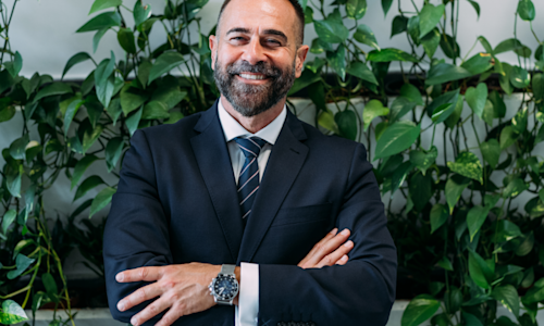 Business man smiling at camera with arms folded confidently