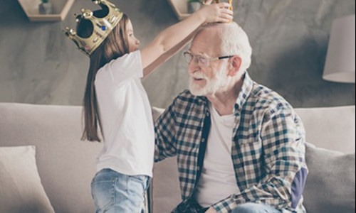 a senior client plays with his granddaughter