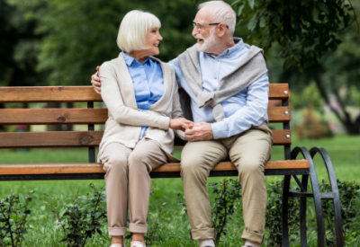 An older couple sitting at a park bench thinking about long-term care.