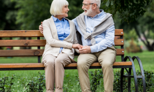 An older couple sitting at a park bench thinking about long-term care.