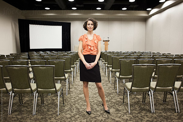 Woman standing in an empty meeting room.