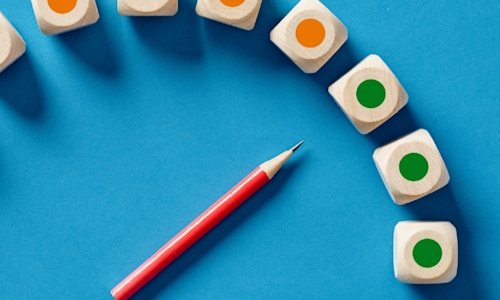 Pencil and blocks showing progression from orange to green, insinuating positive change