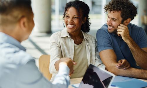 Smiling couple shaking hands with man