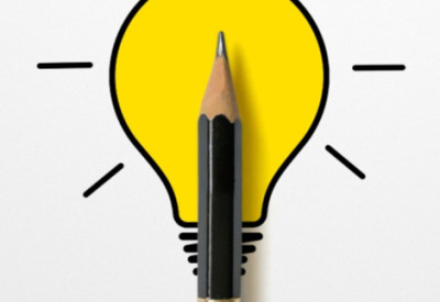 An illuminated lightbulb drawing with a small black pencil placed over it