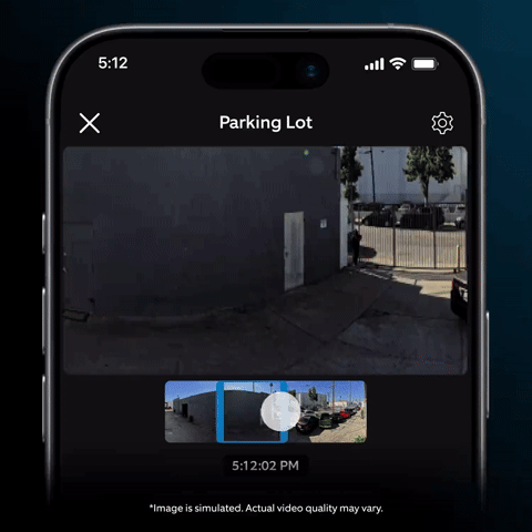 Ring Elite 180 4K - Smartphone screen showing a parking lot camera feed with timeline scrubber at 5:12 PM, industrial buildings and fence in view.