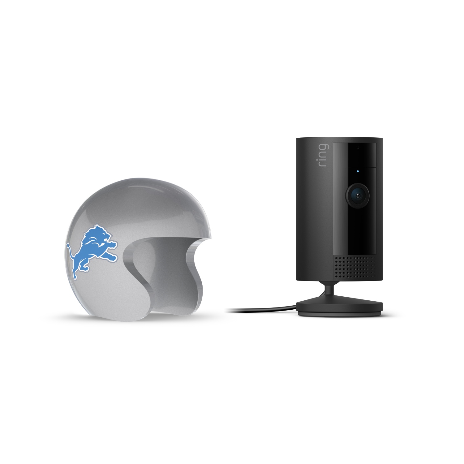 Indoor Cam, Black + NFL Game Day Cam Cover — NFC - Black Ring indoor camera on a stand next to a gray helmet with a blue lion logo, set against a white background.