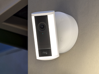 White Spotlight Camera Pro (2nd Gen) mounted to beige wall, illuminated