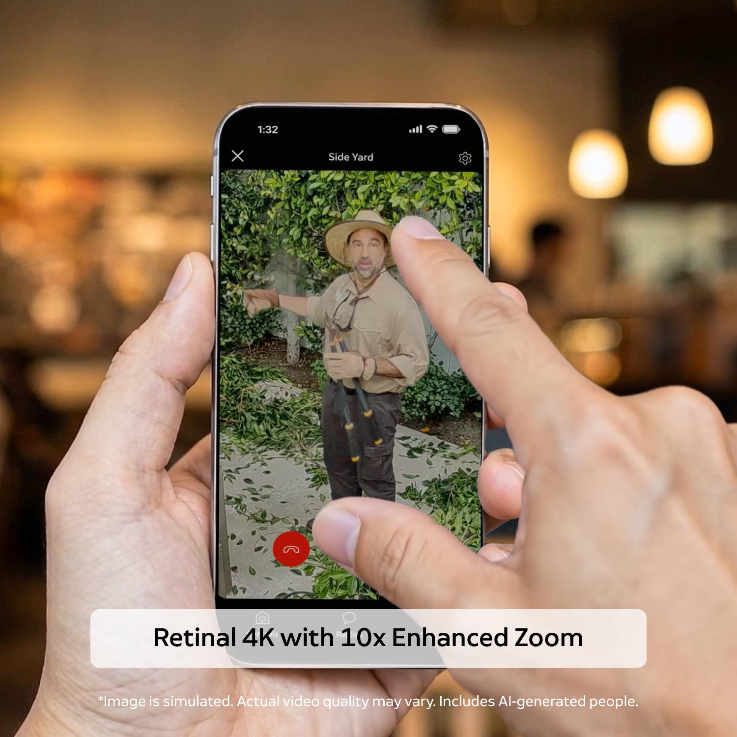 Outdoor Cam 4K Plus  - Hands holding a smartphone showing a garden scene with a person trimming hedges, demonstrating a zoomed 4K video view indoors.
