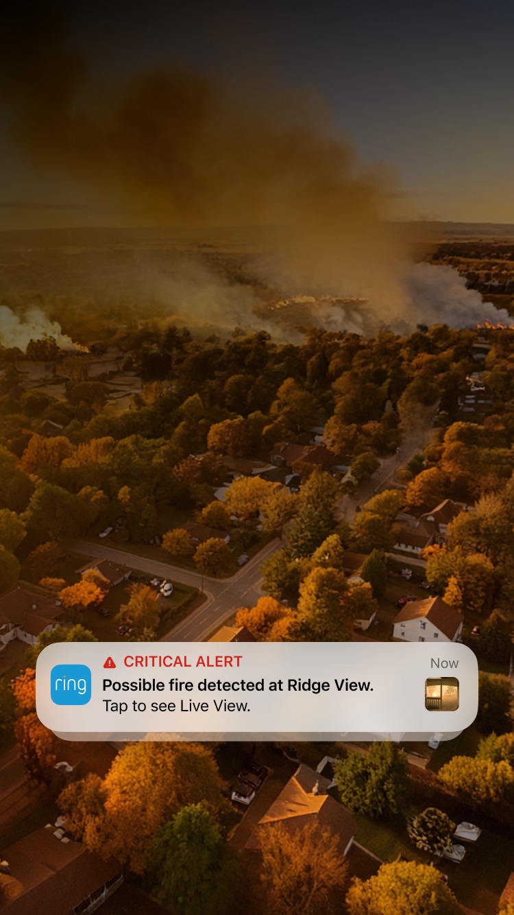 Aerial view of neighborhood with wildfire smoke and Ring notification alert showing 
