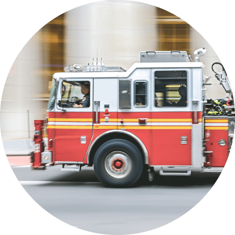 A fire truck is driving quickly through a city in response to an emergency.