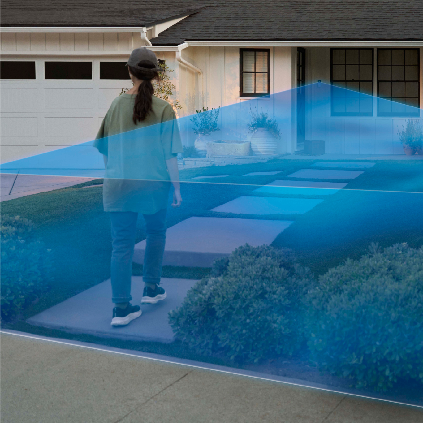 A woman walks into a driveway covered in a blue laser graphic extending out from a Ring Wired Doorbell Plus  mounted to the house.