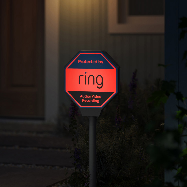 Ring Yard Sign is illuminated at night in the front yard of a home