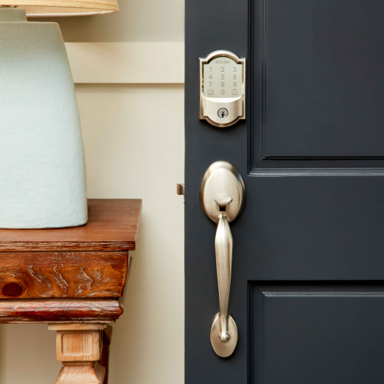 Slightly open dark blue door equipped with a Schlage Encode Smart Wi-Fi Deadbolt with keypad.