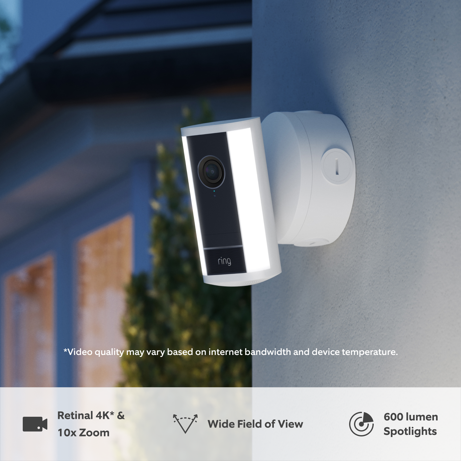 Spotlight Camera Pro (2nd Gen) (Featuring Retinal 4K) - Power over Ethernet:White Ring Spotlight Cam Pro (2nd Gen) with a Power over Ethernet adapter attached to a wall at dusk in the rain with built-in LED spotlights illuminated 