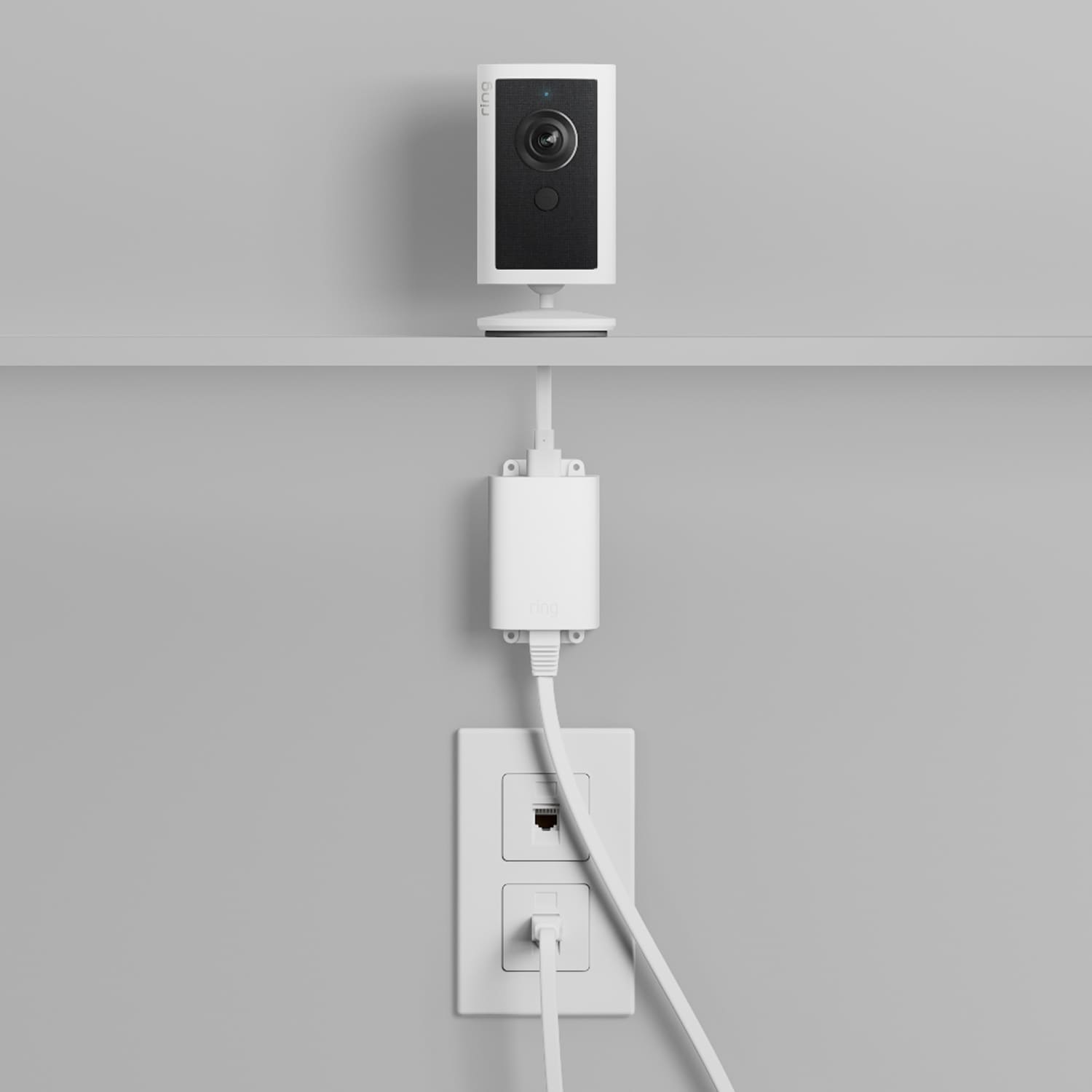 Indoor Cam 4K - Power Over Ethernet:Indoor Cam 4K mounted to a wall. Power cord stretches down the wall from the camera base.