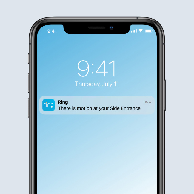 A smartphone screen displays a Ring App notification reading, 'There is motion at your Side Entrance,' indicating real-time motion detection alerts.