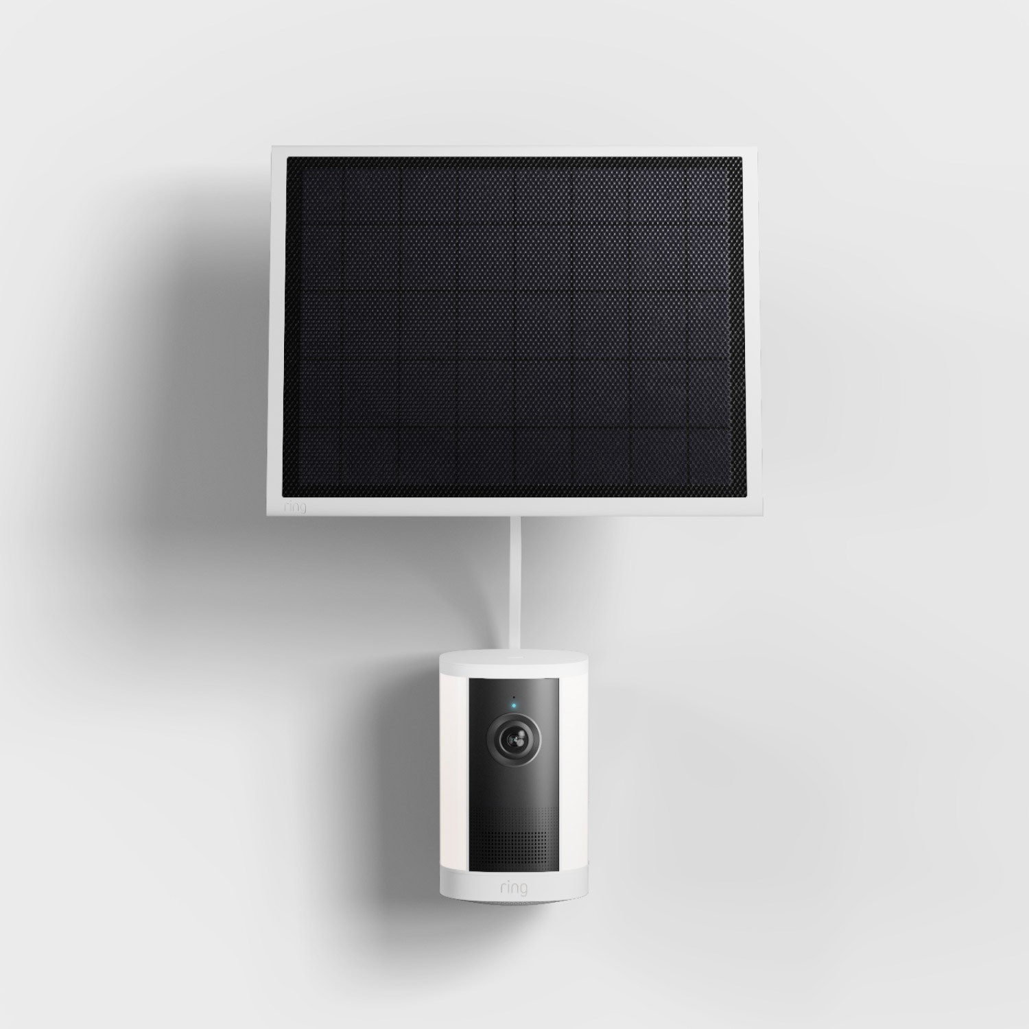 Spotlight Cam 4K Plus - Solar:White Ring security camera mounted on a wall beneath a square black solar panel, connected by a short cable.