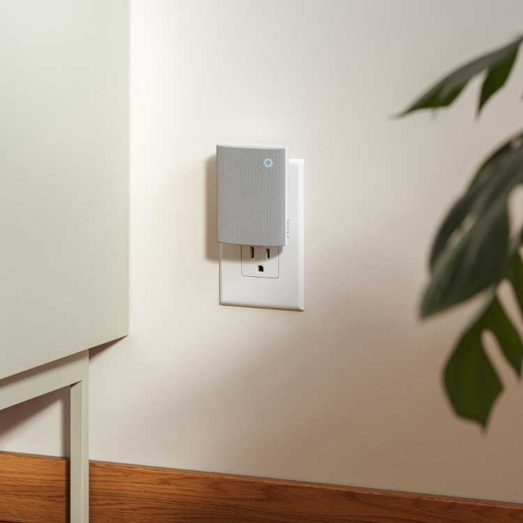 Ring's Chime (3rd Gen) plugged into the living room wall. Credenza and indoor plant shown.