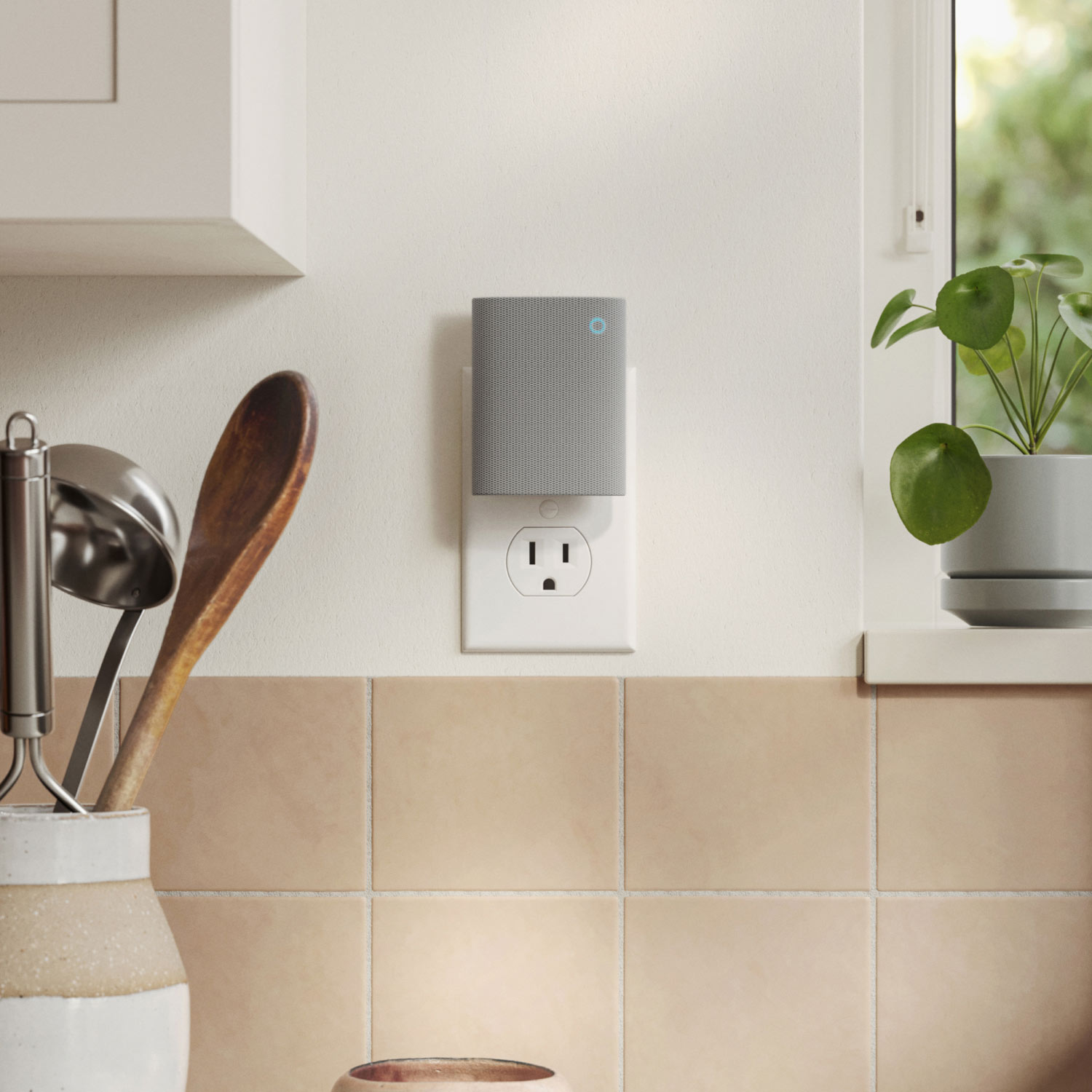 Chime (3rd Gen) - Ring's Chime (3rd Gen) plugged into the kitchen wall. Kitchen cabinetry, utensils, and indoor plant shown.