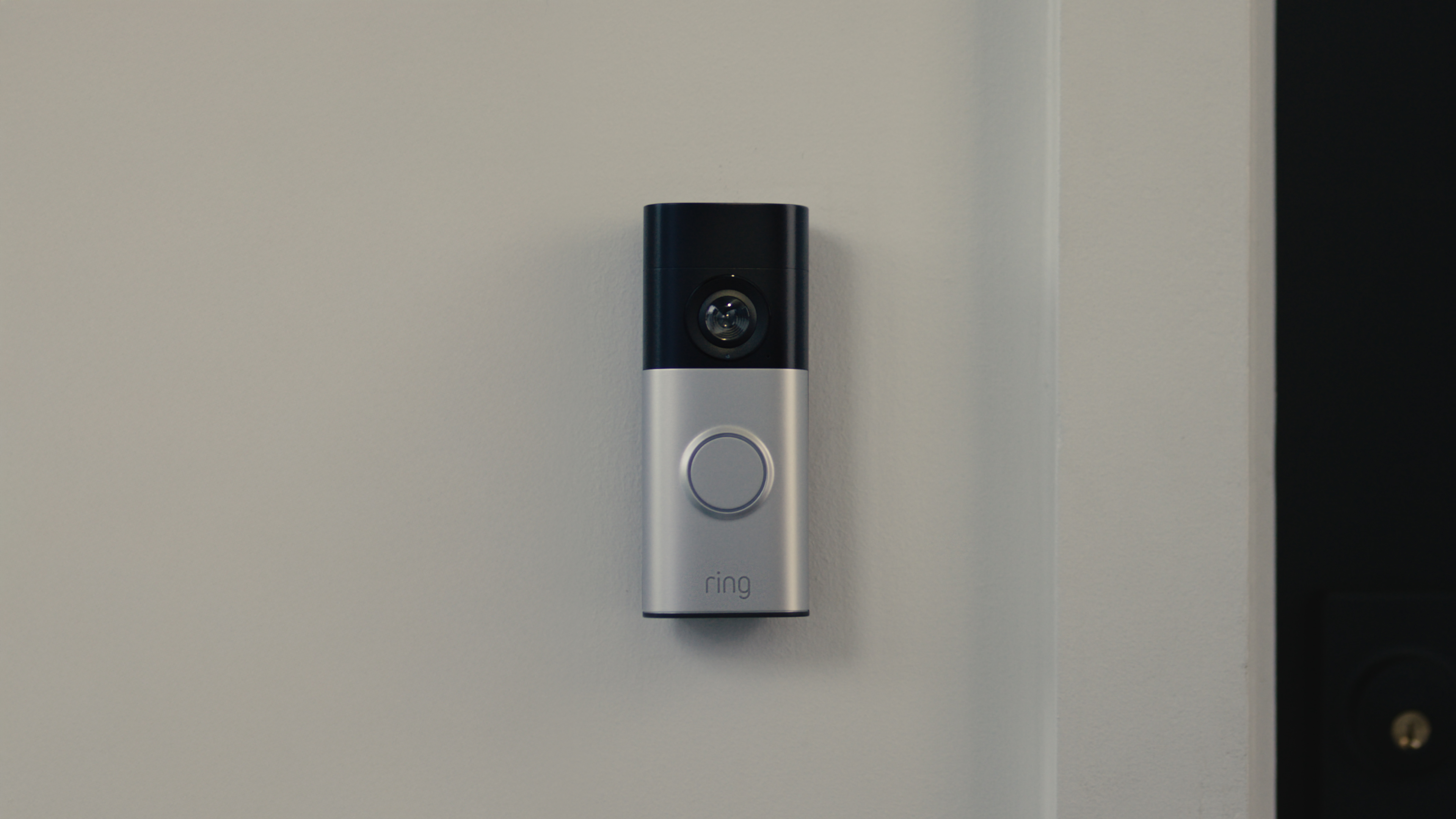 Wired Video Doorbell Plus (2nd Gen) in hand with a green table under the person's hand. 