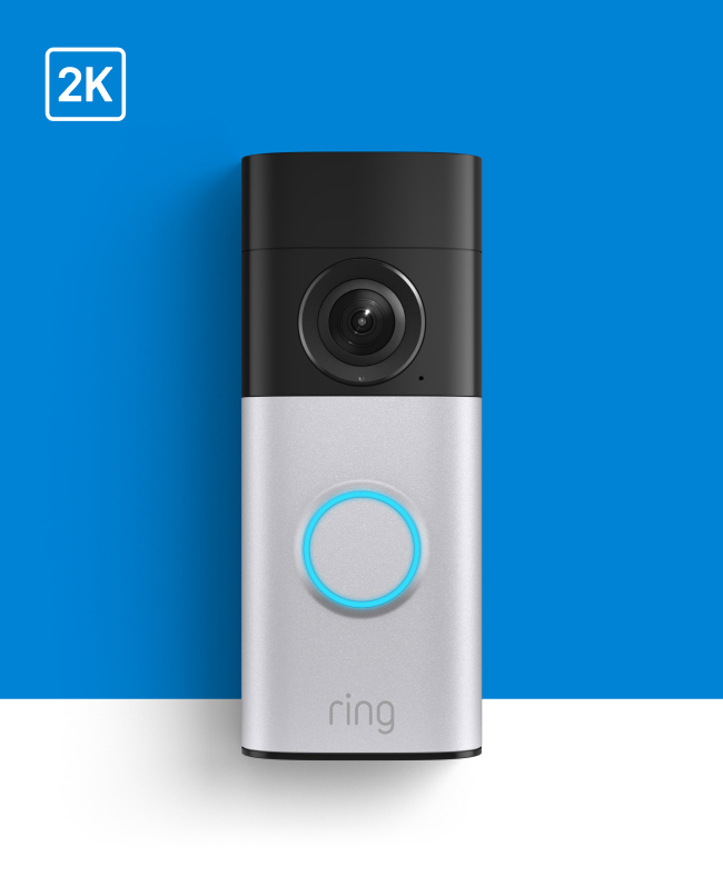 Ring doorbell camera with 2K resolution, silver base, black camera top, and blue illuminated button against blue background.