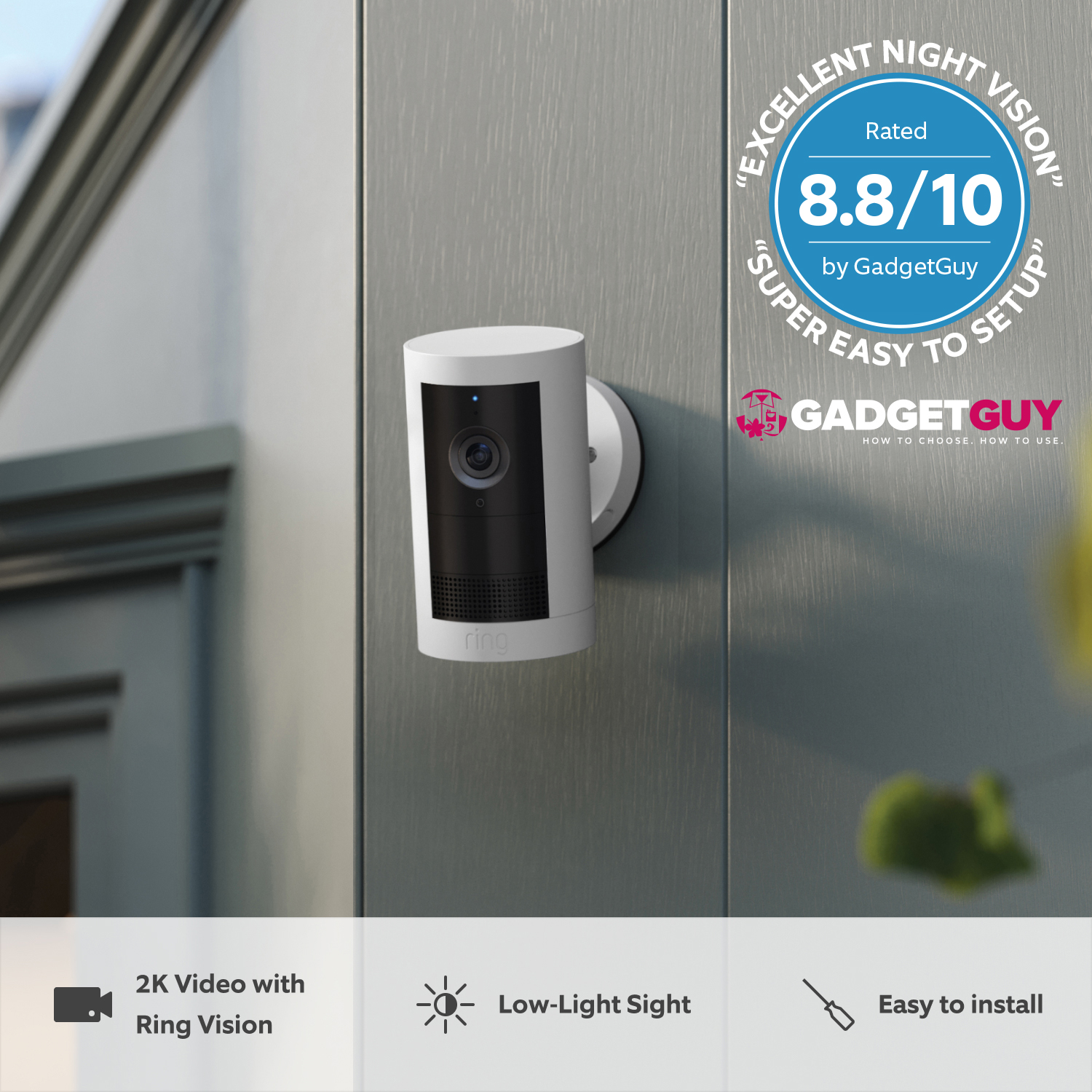 Outdoor Camera Plus (Featuring 2K Video with Ring Vision) - Battery:White Outdoor Security Camera Plus Battery mounted to grey panel wall outdoors. Gadget Guys review badge included with rating of 8.8/10
