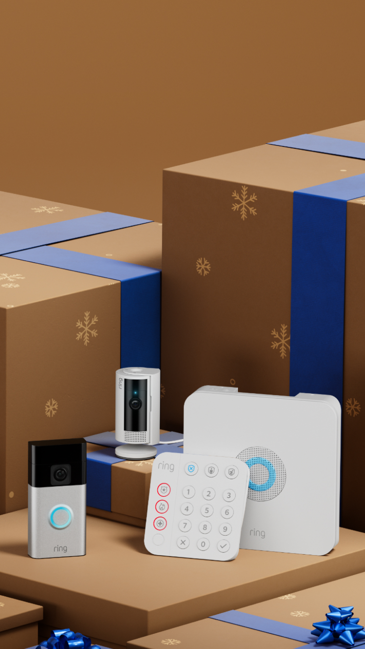 Smart home security devices displayed among brown gift boxes with blue ribbons and snowflake patterns.