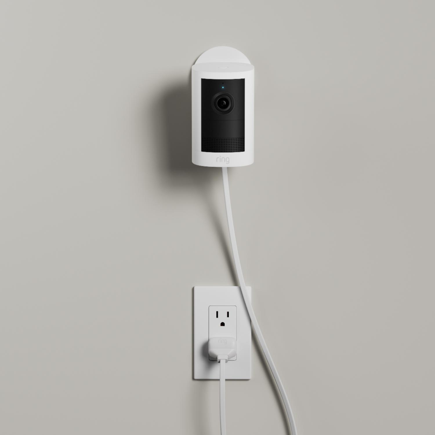 Outdoor Cam (Newest Model)  - Plug-In:White Outdoor Cam (2nd Gen) mounted to a wall. Power cord stretches down the wall from the camera base.
