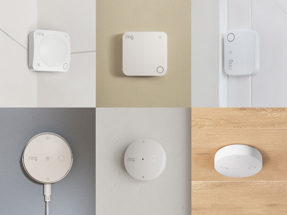 Grid of six white Ring smart home sensors mounted on walls and doors, including motion, contact, and round plug-in devices.