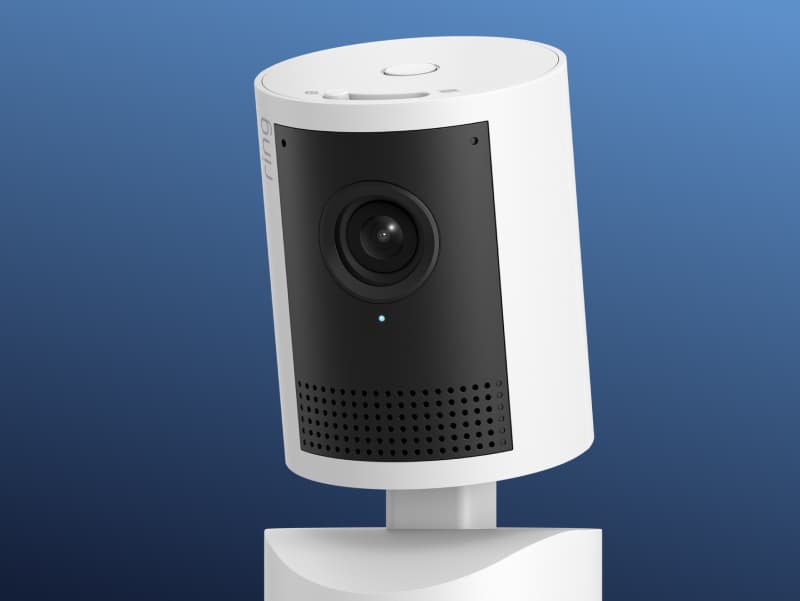 Close-up of a Ring indoor security camera set against a blue gradient background.