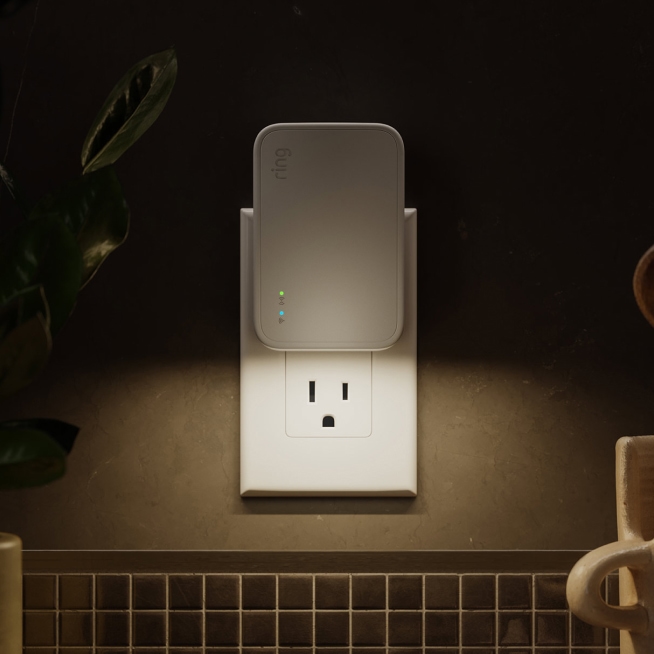 Bridge (2nd Gen) plugged into a kitchen outlet. It is emitting a warm light underneath it.