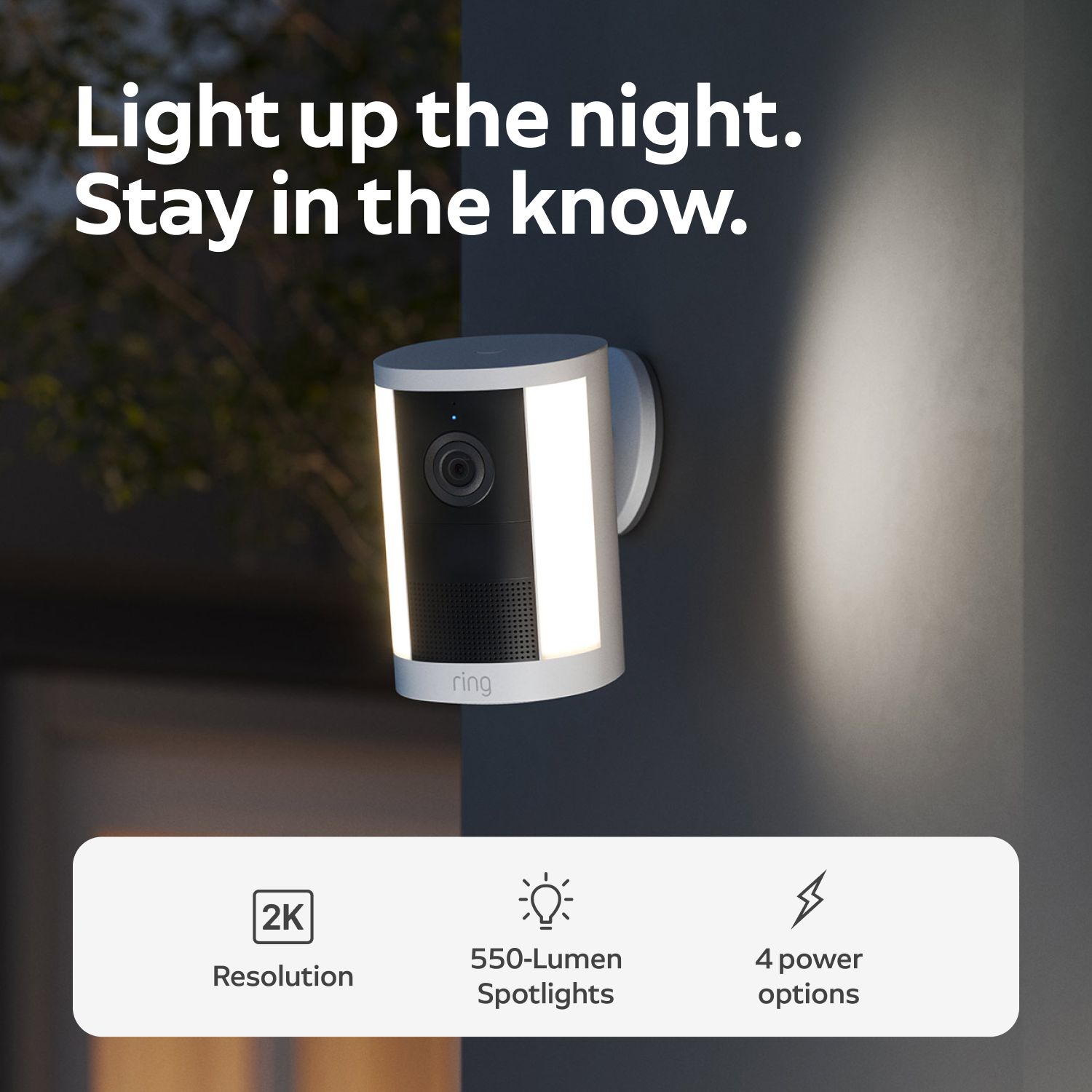 Spotlight Cam 2K - Battery:Wall-mounted Ring camera with dual LED spotlights glowing at night, shown with text highlighting 2K resolution and 4 power options.