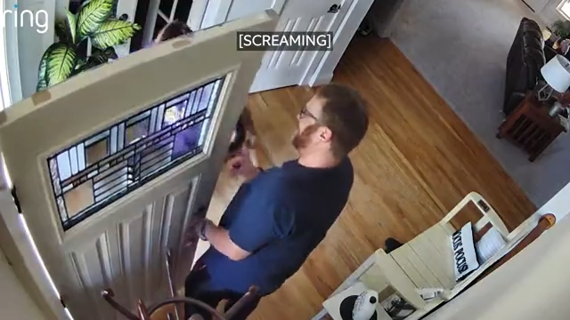 A man scares a young boy as he walks inside the house.