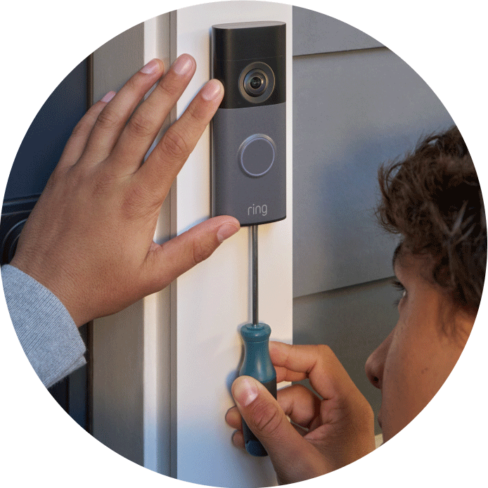 Close-up of hands securing a Wired Doorbell Pro (2nd Gen) onto its mounting bracket. 