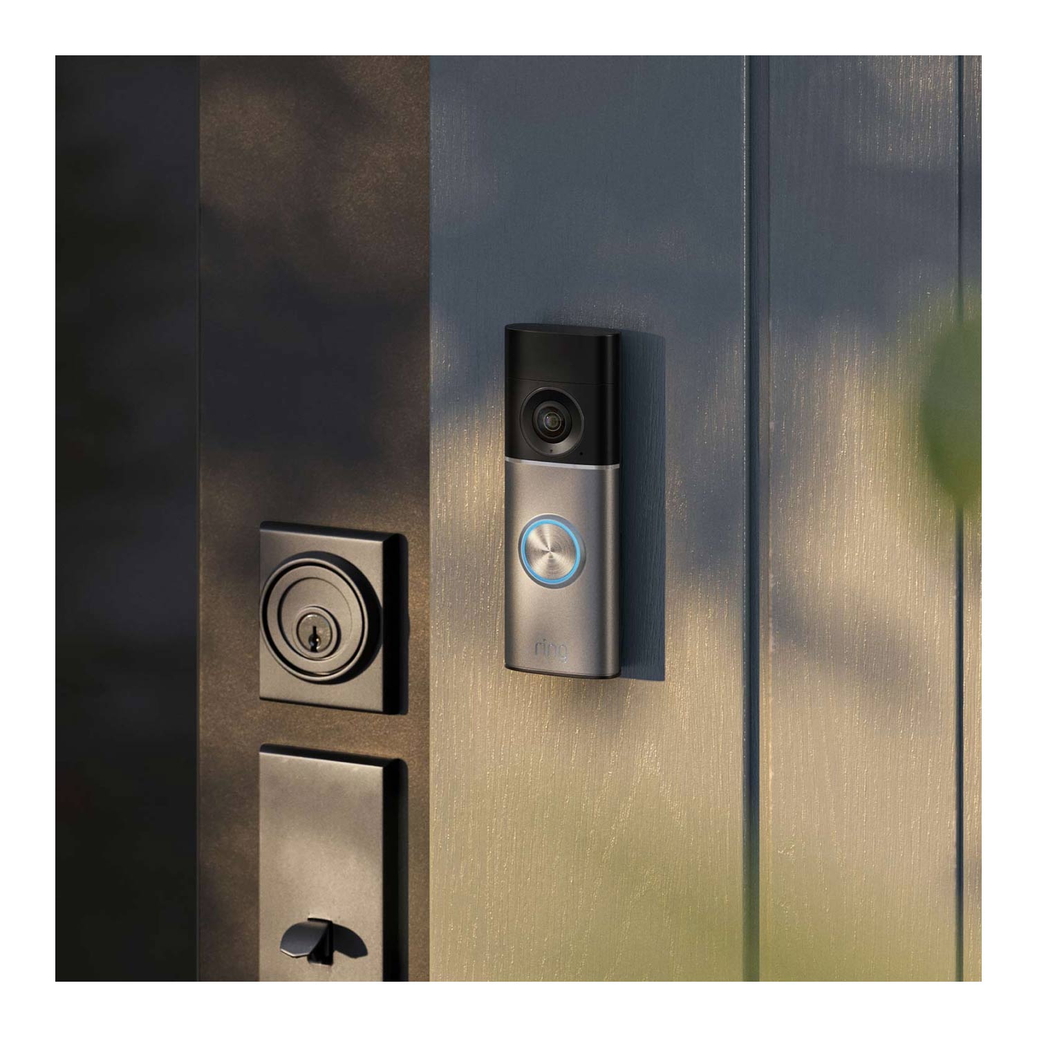 Wired Doorbell Pro (Newest Model) (Featuring Retinal 4K) - Wired Doorbell Pro (2nd Gen) mounted on a dark wooden door next to a door lock, with natural lighting creating a subtle marbled shadow effect across the surface. 