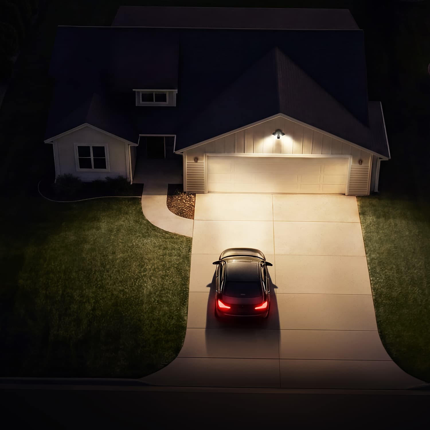 Floodlight Cam - Night aerial of a suburban house with a lit garage and camera above the door, as a black car with red taillights parks in the driveway.