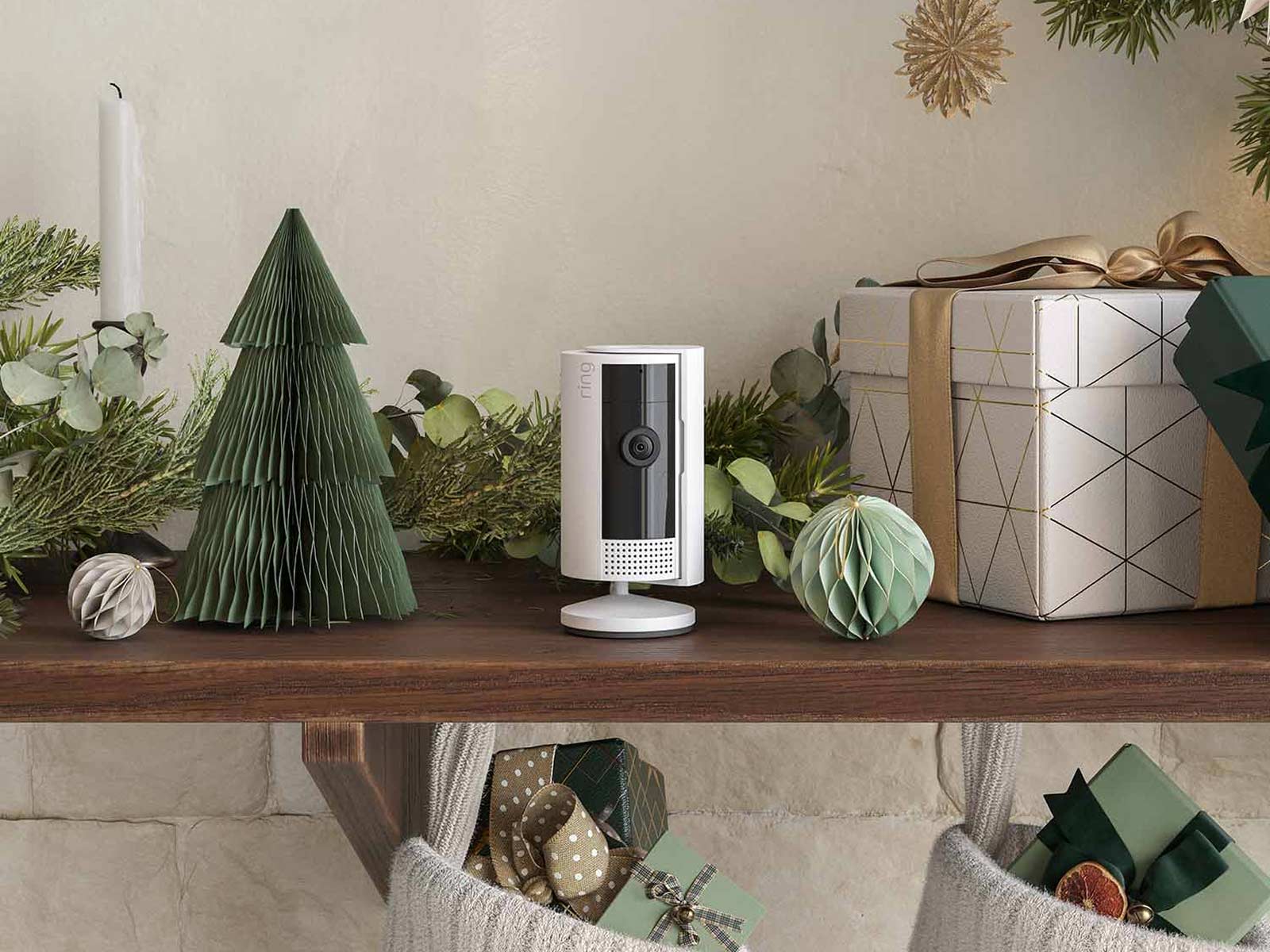 Hand knocking on a door beside a Ring Peephole Cam mounted on a smooth grey surface.